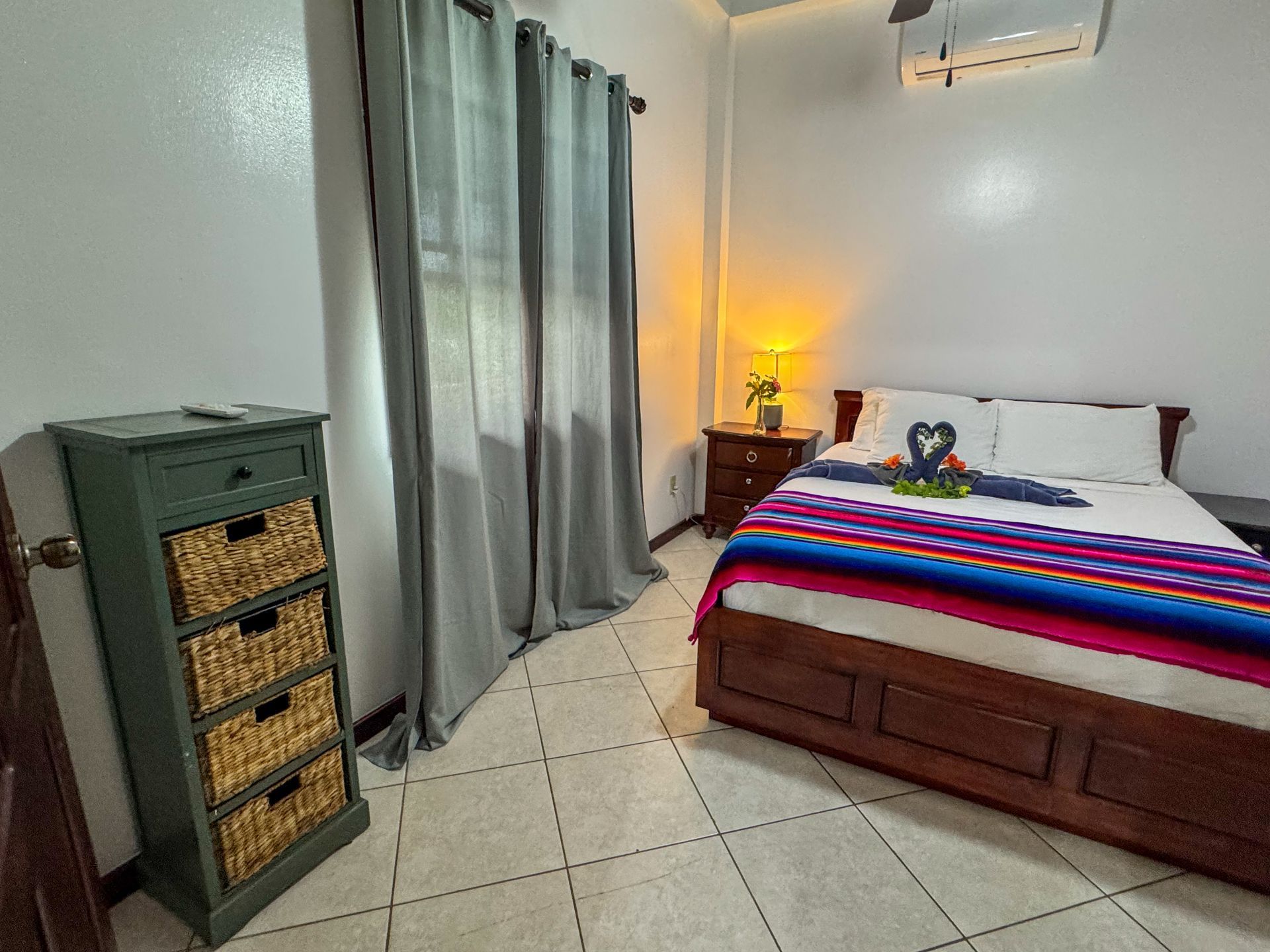 A bedroom with a bed , nightstand , and dresser.