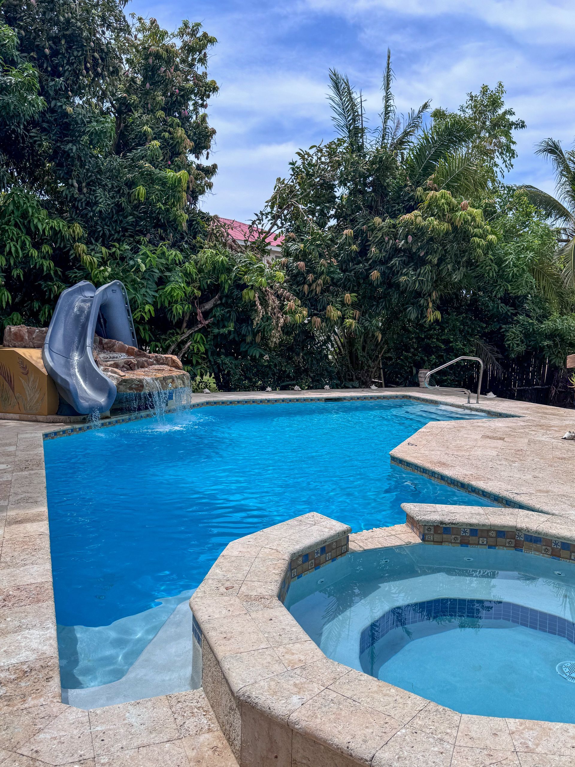 Crystal-clear swimming pool with lounge chairs at Caribbean Shores Bed & Breakfast near the Caribbean Sea.