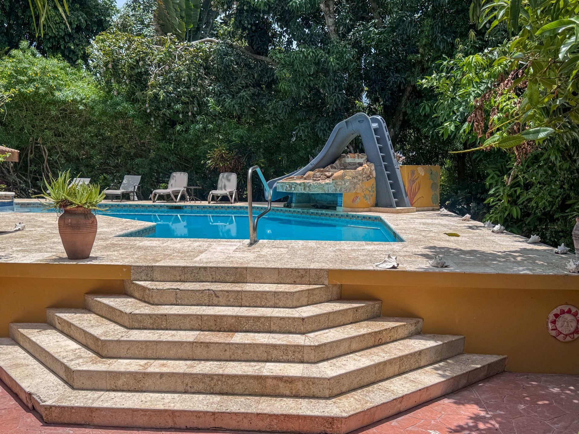 Caribbean Shores Bed & Breakfast outdoor swimming pool surrounded by tropical gardens in Hopkins, Belize.