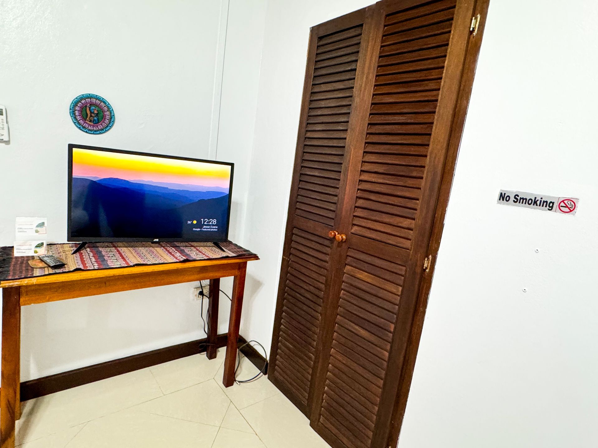 A room with a wooden table and a flat screen tv.