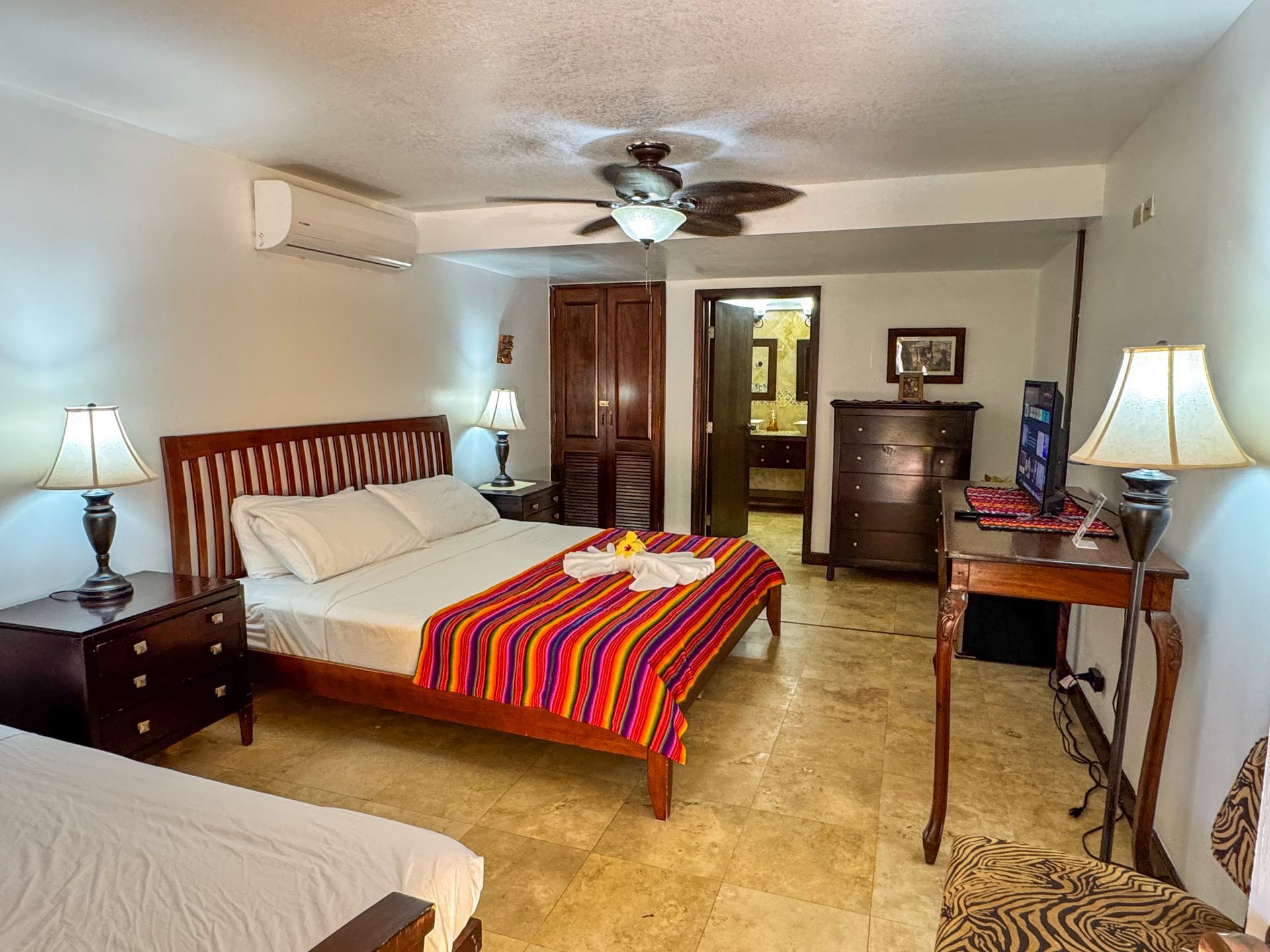 A hotel room with two beds and a ceiling fan