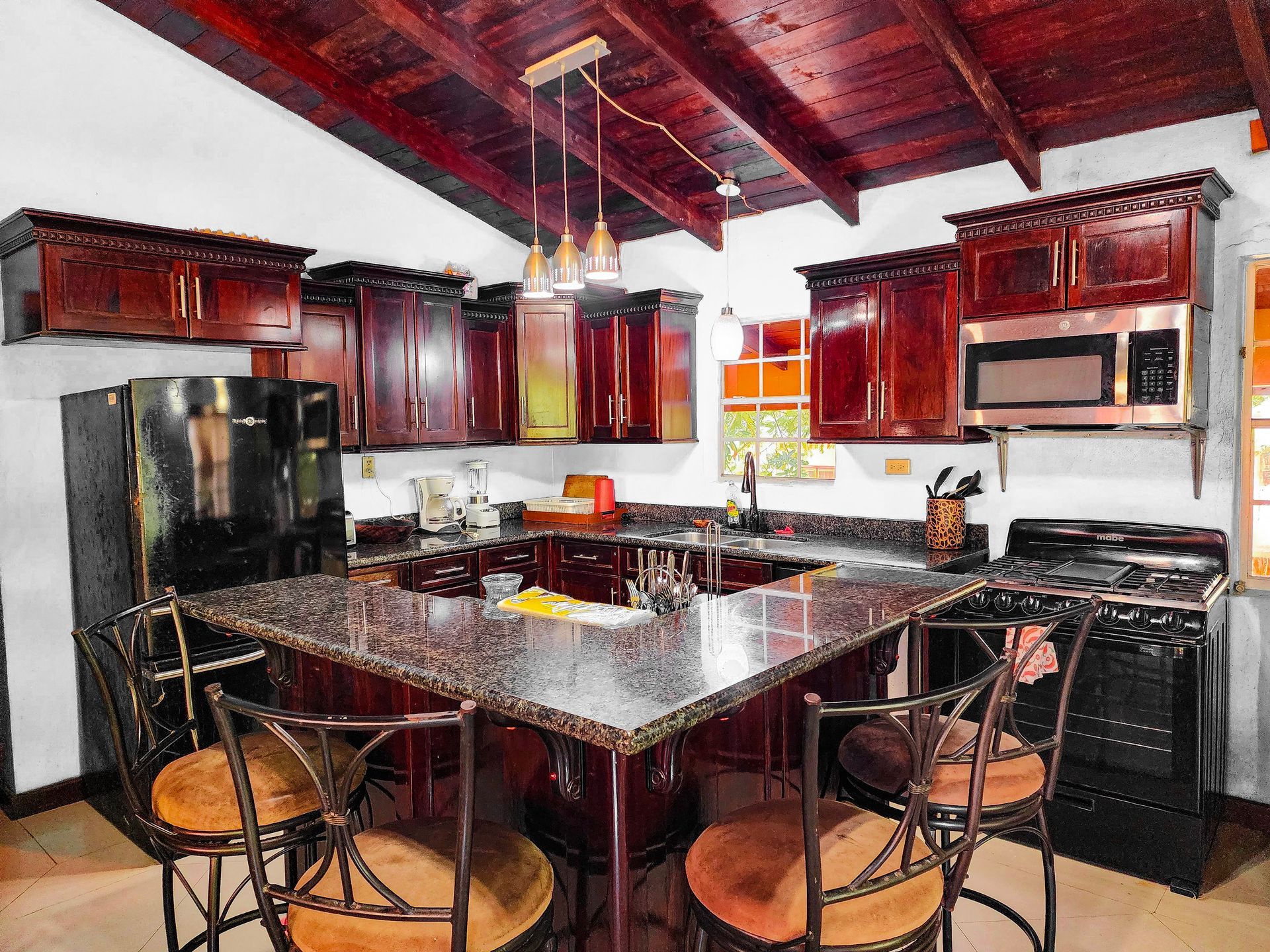 A kitchen with granite counter tops and stainless steel appliances, common area Kitchen at Caribbean Shores B&B, Belize