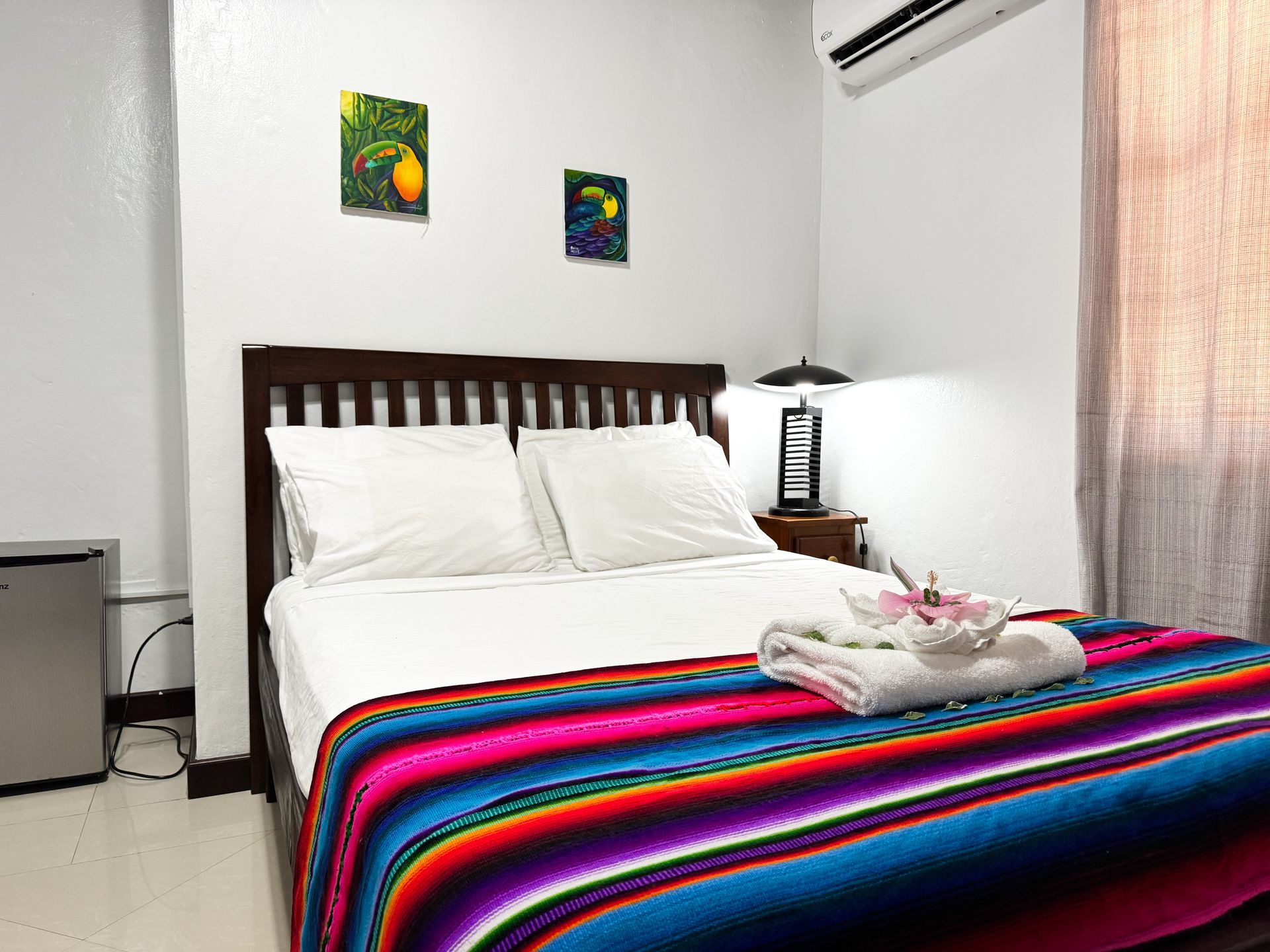 A bedroom with a bed and a colorful blanket, perfect room for solo travelers in Hopkins, Belize