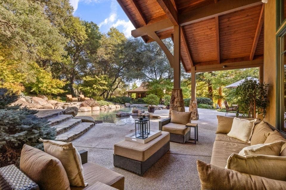 Soaring eaves provide cover for various outdoor living spaces.