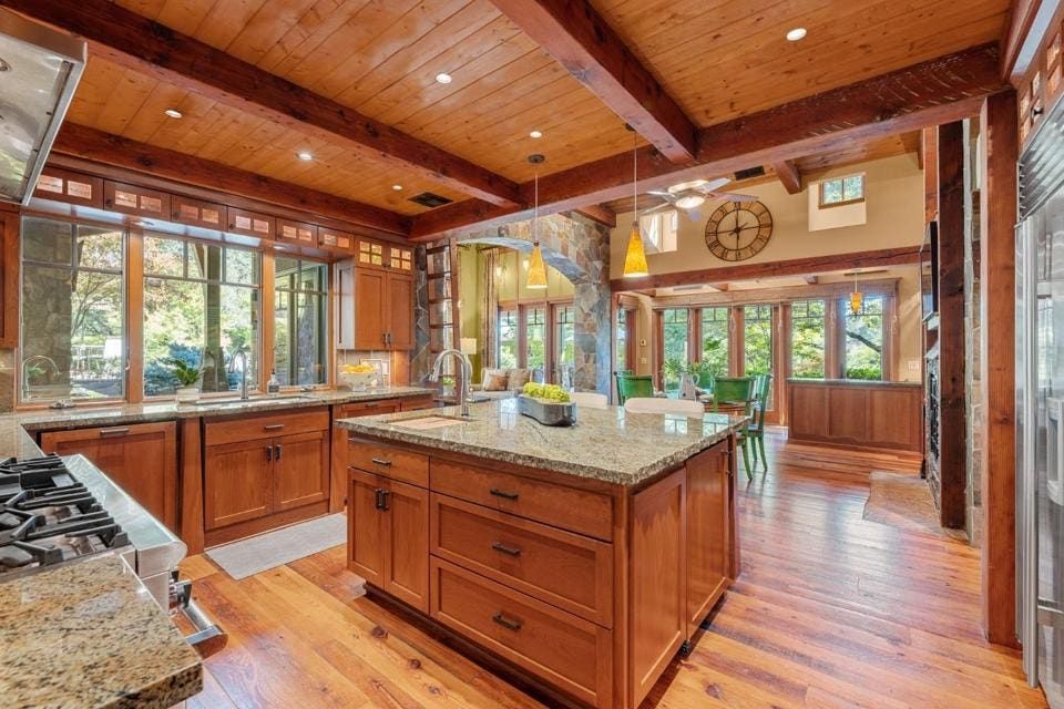 Craftsman details include multipaned windows, use of natural materials, deep eaves and plinth-based columns.