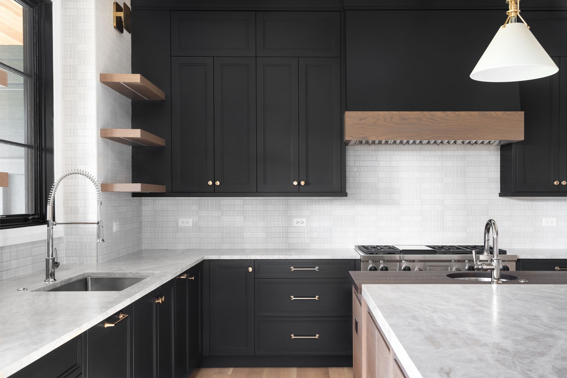 Cuisine moderne en noir et blanc avec comptoirs en marbre, étagères ouvertes et luminaires suspendus