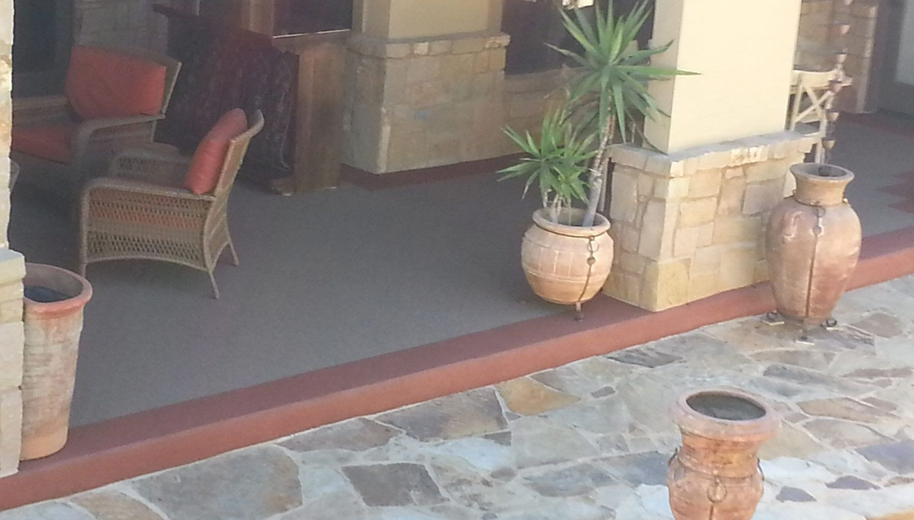 Granite Coatings A patio with potted plants in front of a house