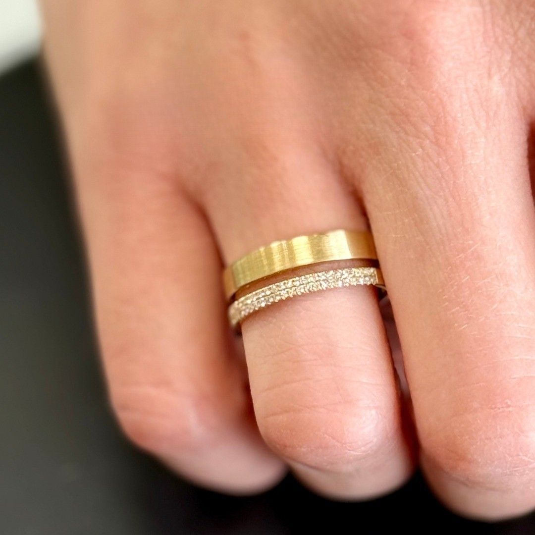Close-up of a hand wearing two gold rings