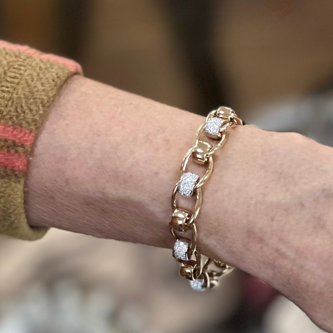 Close-up of a wrist wearing a gold bracelet with diamond accents
