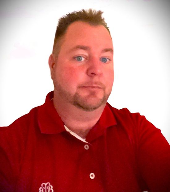 TJ Laughman is wearing a red polo shirt