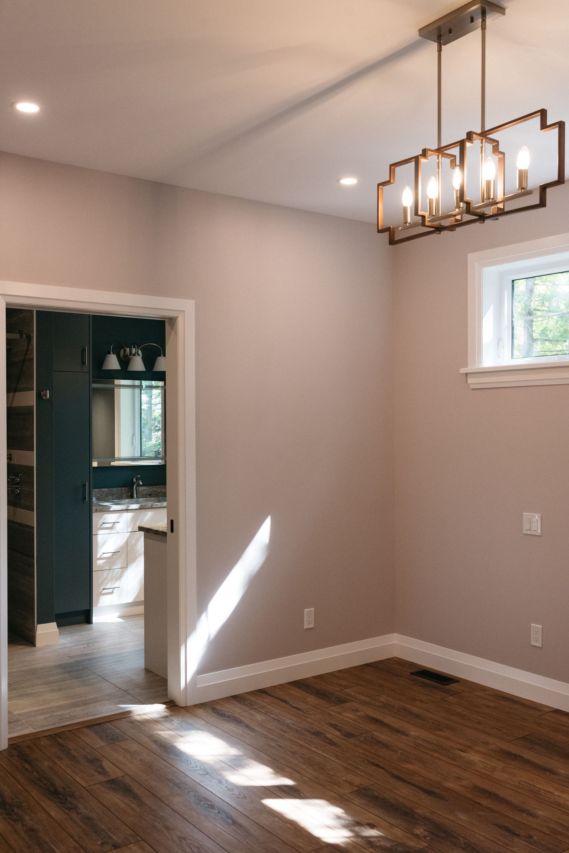 The view from a bedroom of a custom bathroom with vanity and walk in shower