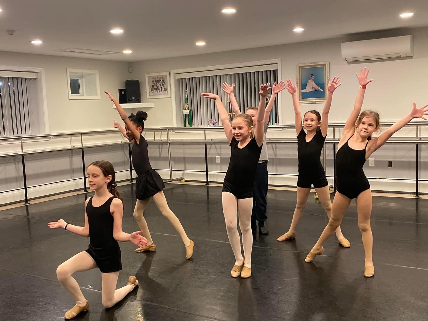A group of young girls are dancing in a dance studio.