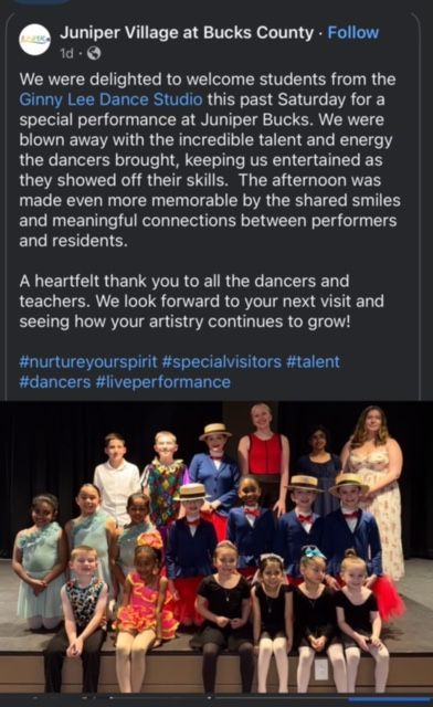 Dance troupe onstage with seated performers and trophies at Juniata Village stage show