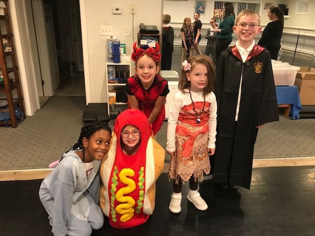 Children in Halloween costumes posing indoors, including a hot dog and a vampire outfit.