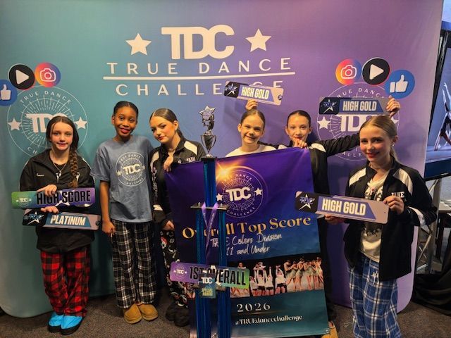 Six dancers hold awards at a True Dance Challenge podium in front of a purple event backdrop.