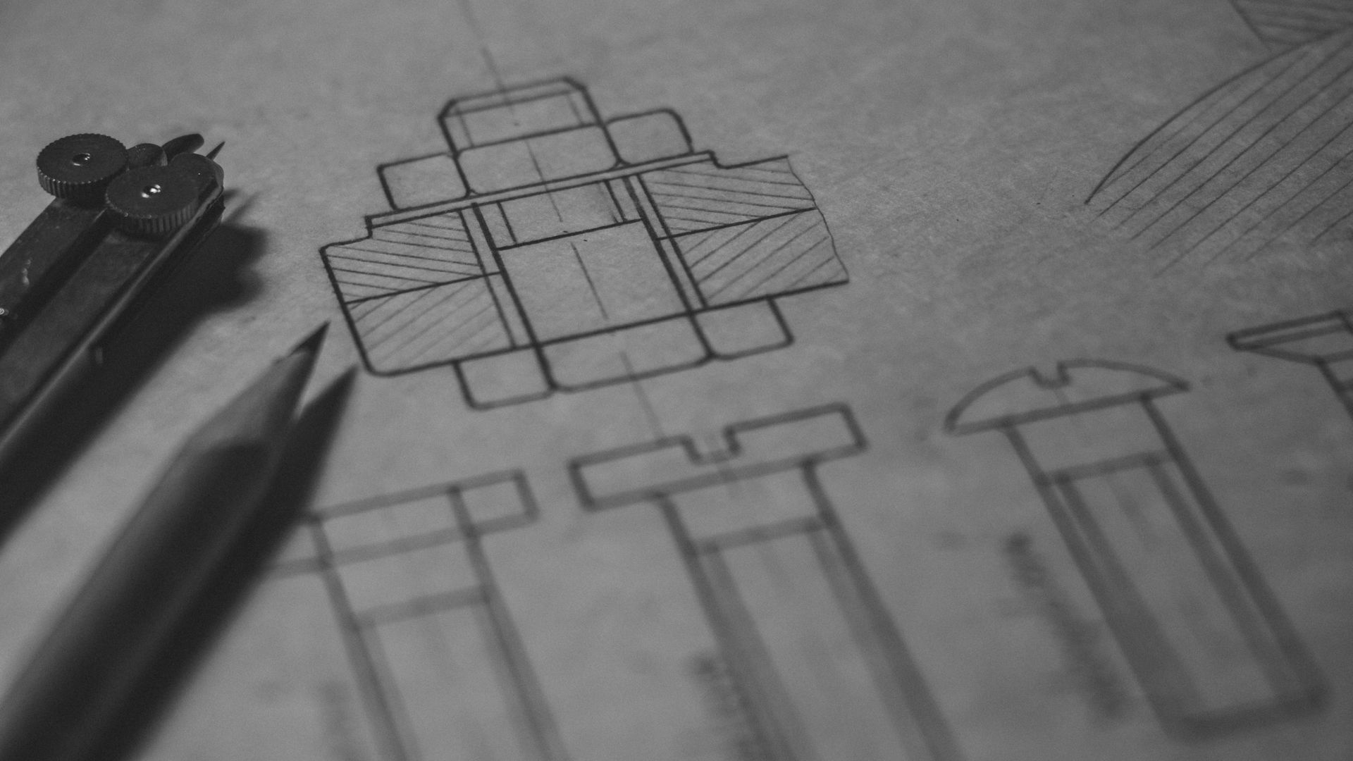 Blueprint with detailed mechanical drawings, a compass, and a pencil.