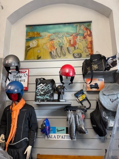 Esposizione di caschi, borse e opere d'arte dedicate alla Vespa.