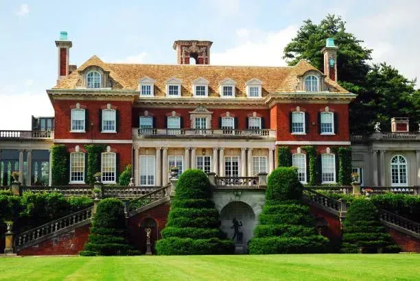 A large brick house with a lush green lawn in front of it