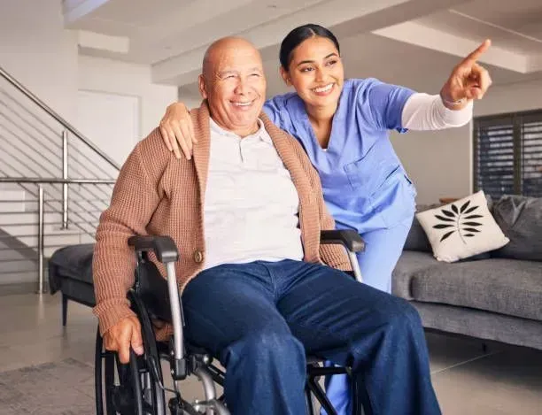 A nurse is helping an elderly man in a wheelchair.