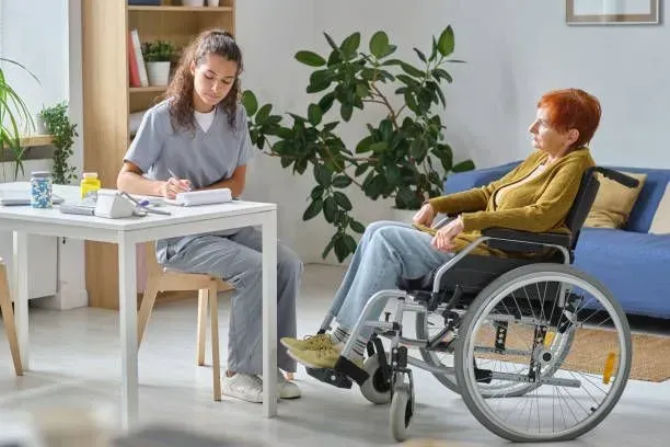A nurse is talking to an elderly woman in a wheelchair.