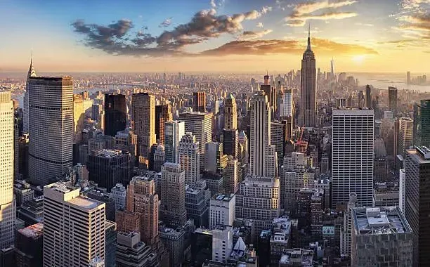 An aerial view of the new york city skyline at sunset.