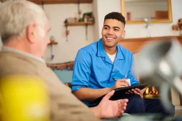 A young man is sitting on a couch talking to an older man.