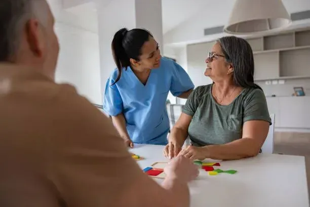 A woman is sitting at a table with a man and a nurse.