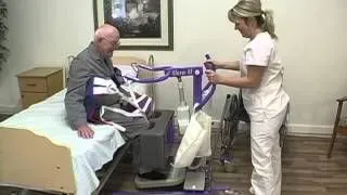 A nurse is helping an elderly man get out of a hospital bed.