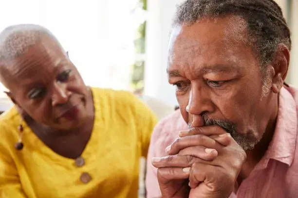 A man and a woman are sitting next to each other on a couch.