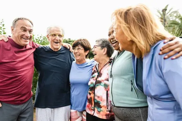 A group of older people are standing next to each other and laughing.