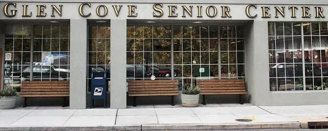 The front of glen cove senior center with two benches in front of it