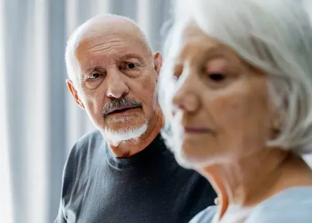 A man and a woman are standing next to each other and looking at the camera.