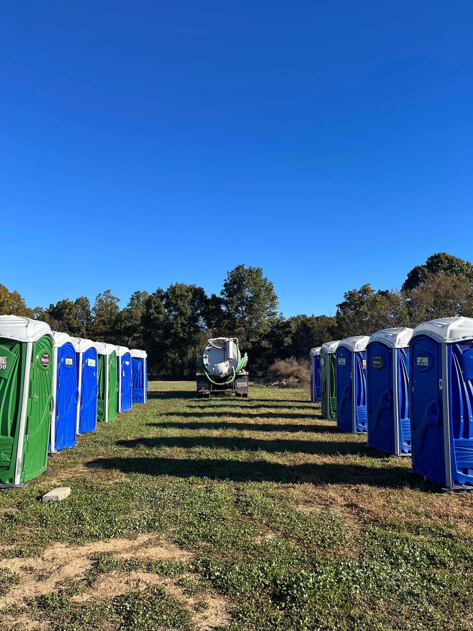 Vacuum truck driving in between portable toilets for rent | West Plains, MO