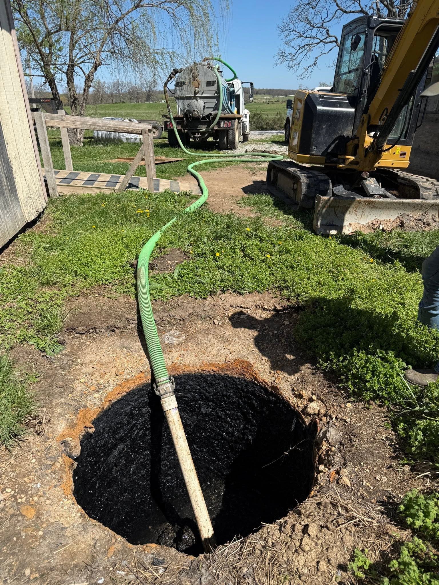 Septic tank pumping and inspection at a Houston, Missouri property with a septic service truck