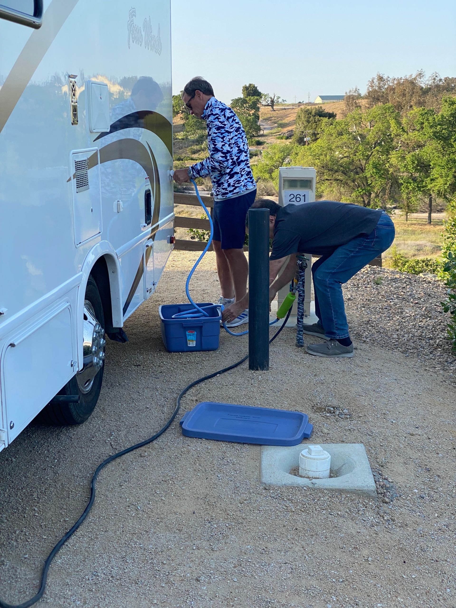 RV owner connecting to campground utility hookup at RV park in Missouri before peak camping season