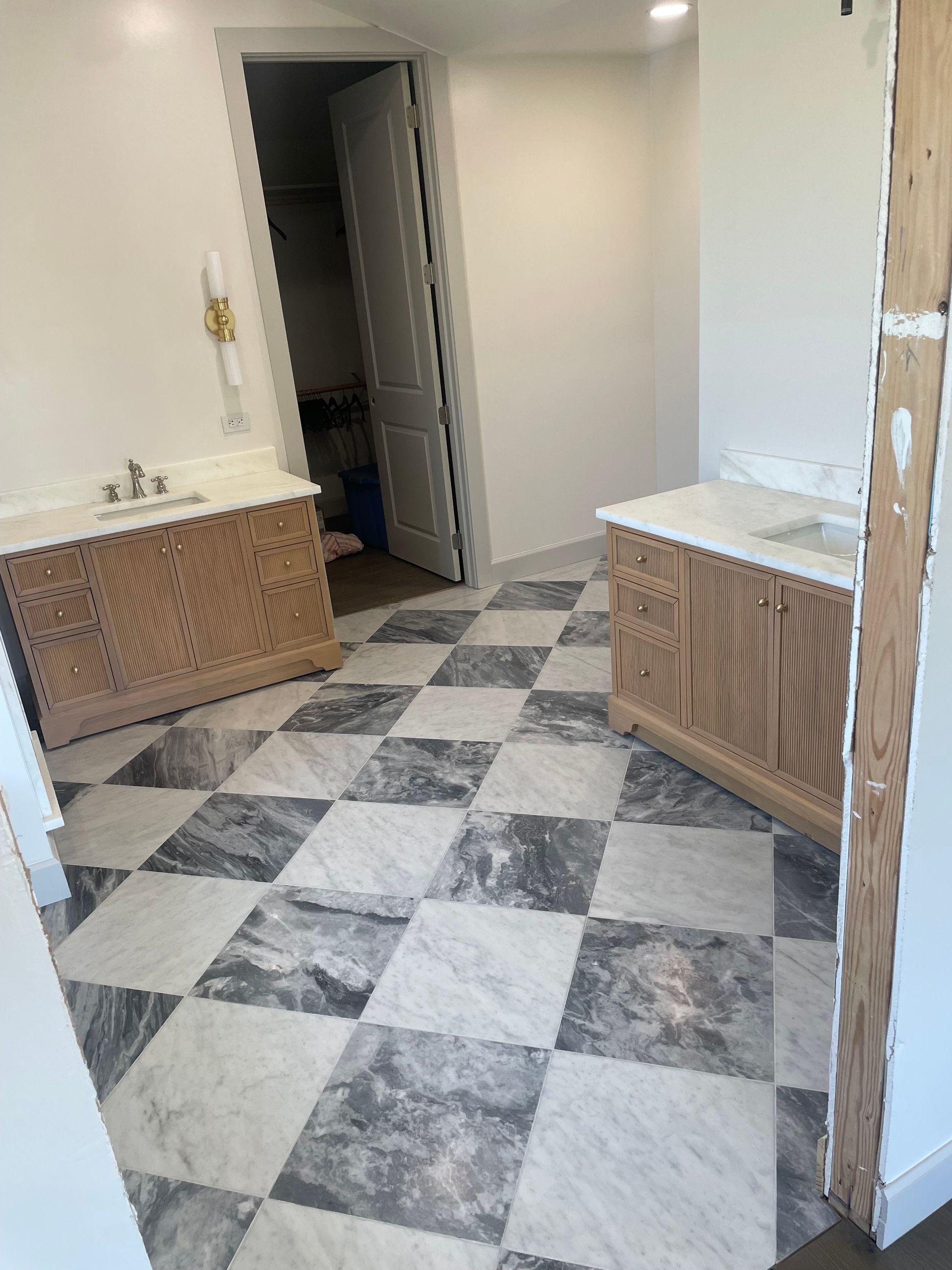 Bathroom with marble tile floor and two wooden vanities. Bathroom with marble tile floor and two wooden vanities.