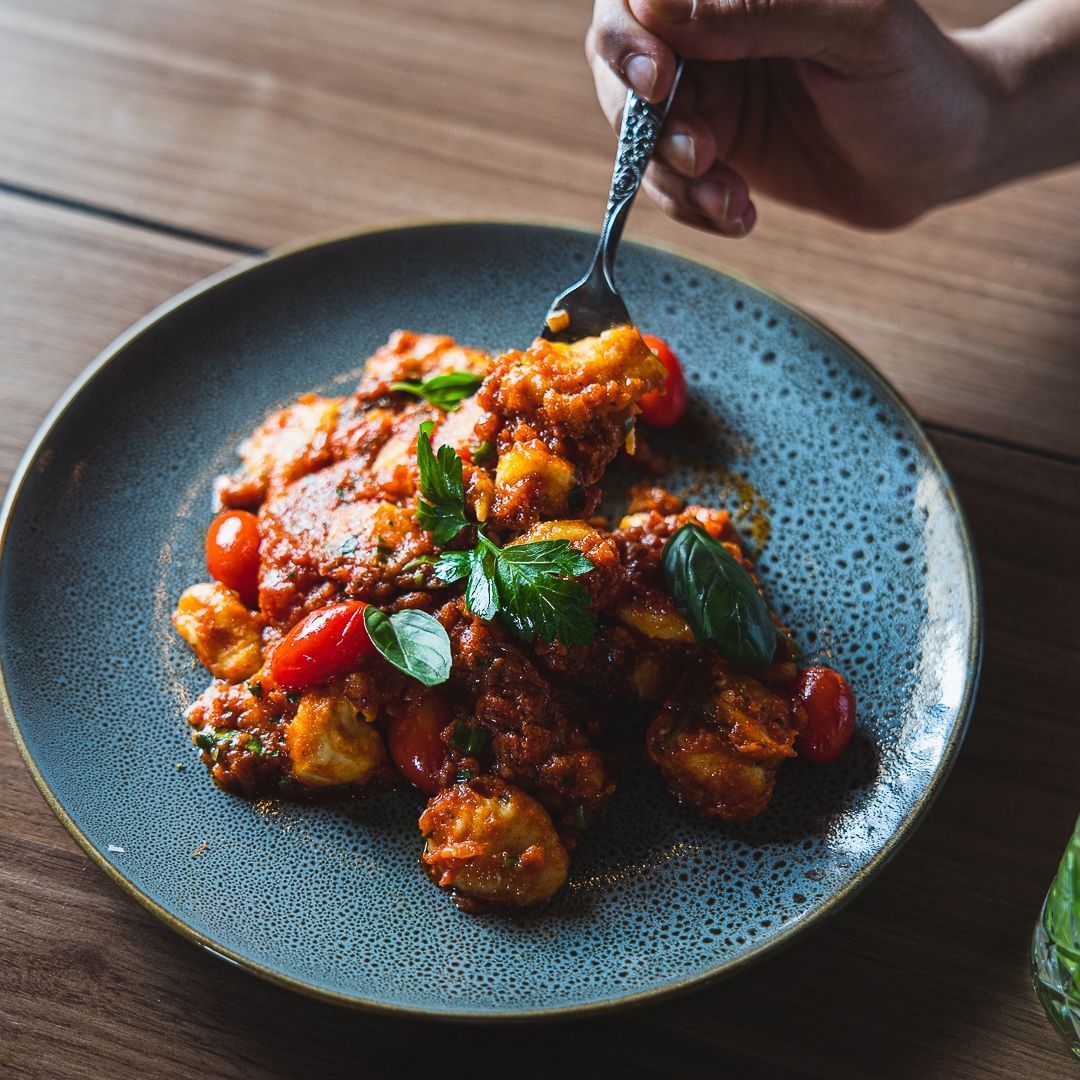a person is holding a fork over a plate of food