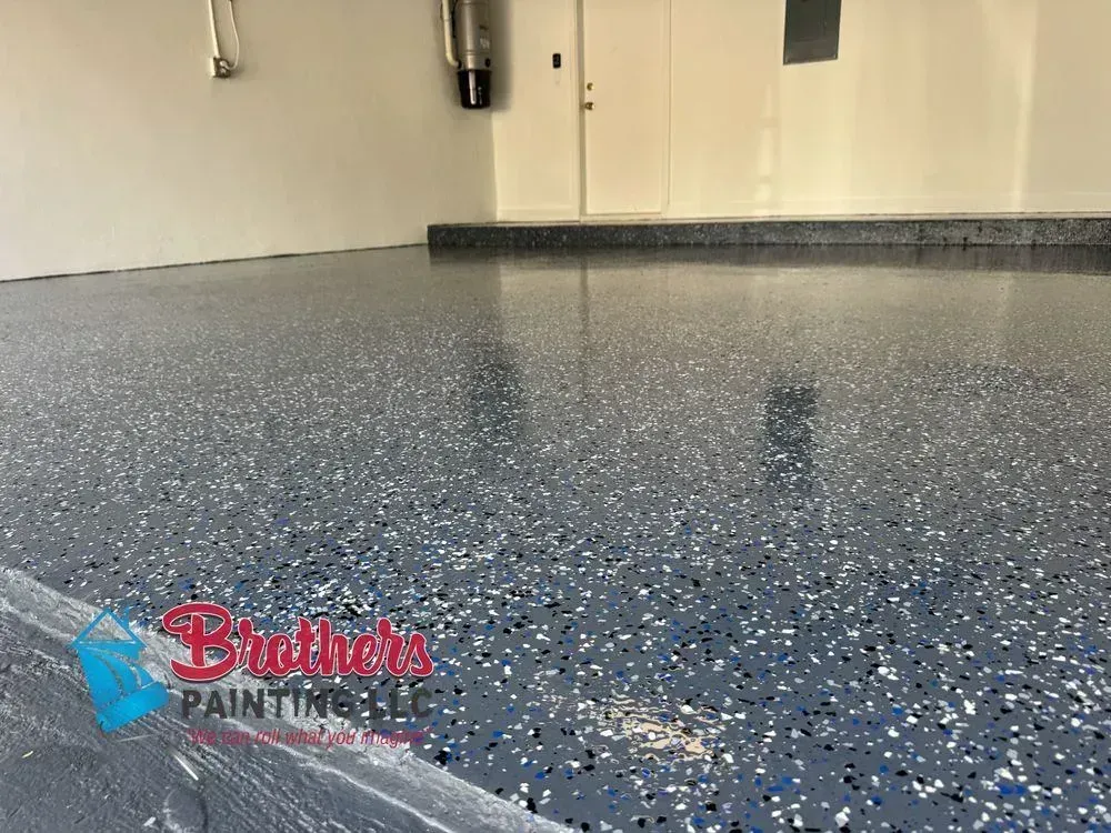 Blue speckled epoxy floor in a garage or utility room with a glossy finish and visible reflection