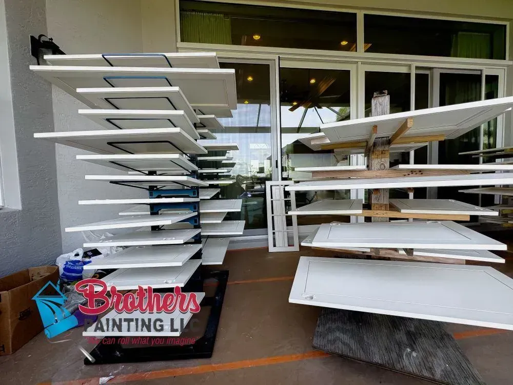 Stair-step racks with freshly painted cabinet doors outside a Brothers Painting business storefront