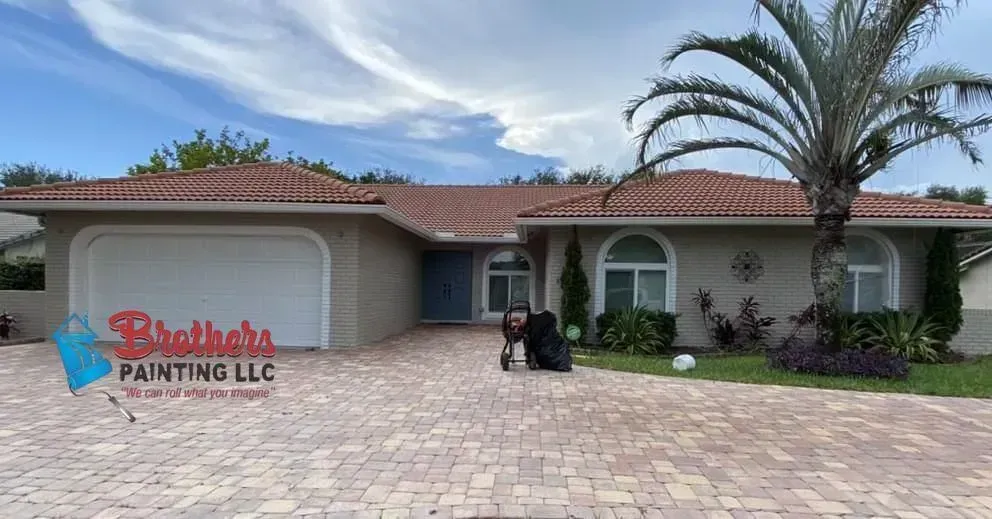 Single-story home with a red tile roof, palm tree, and a “Brothers Painting LLC” sign in the driveway