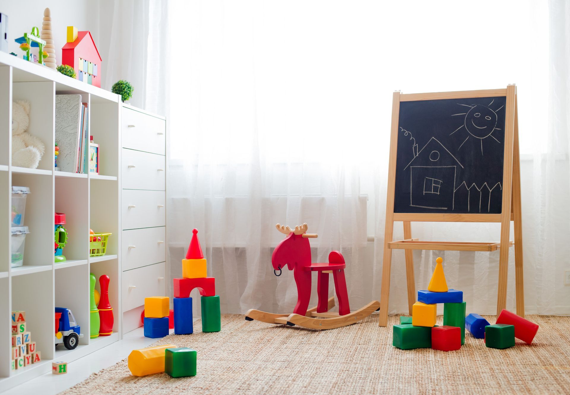 A room filled with lots of toys and a blackboard.