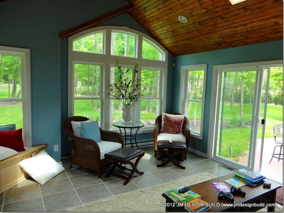 A living room with blue walls and lots of windows.