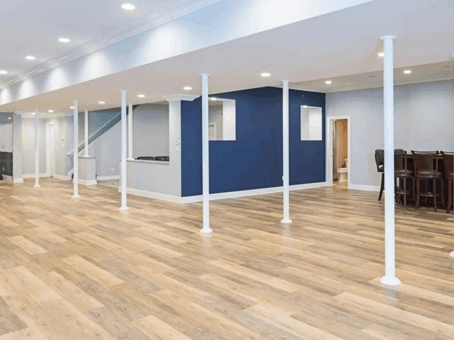 A basement with hardwood floors and blue walls.