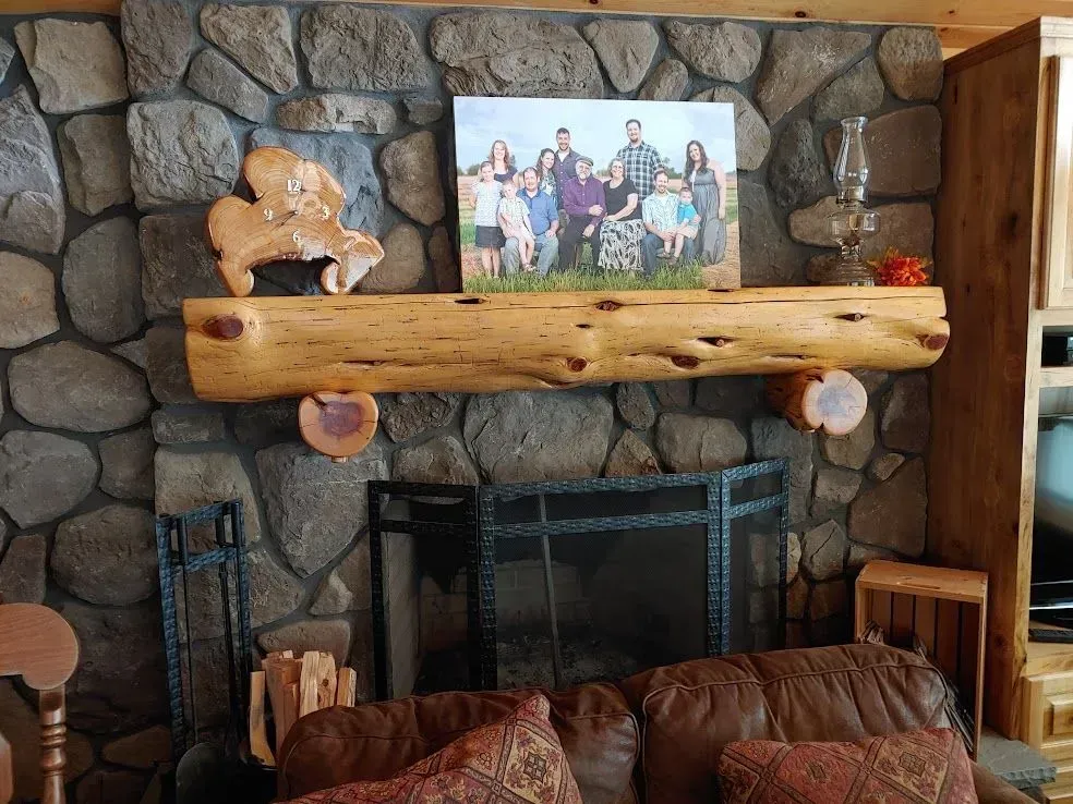 Stone fireplace with wooden mantel, family photo, and rustic bear decor in a cozy living room