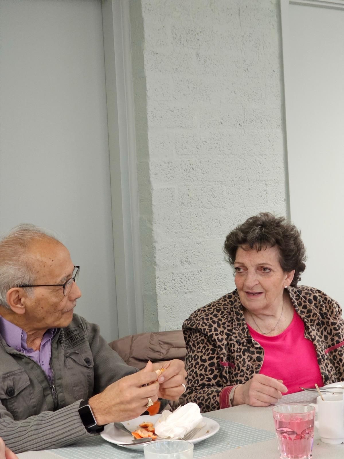 Een man en een vrouw zitten aan een tafel voedsel te eten.