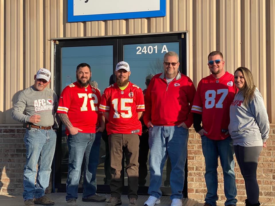 Group of people in Chiefs jerseys outside a building.