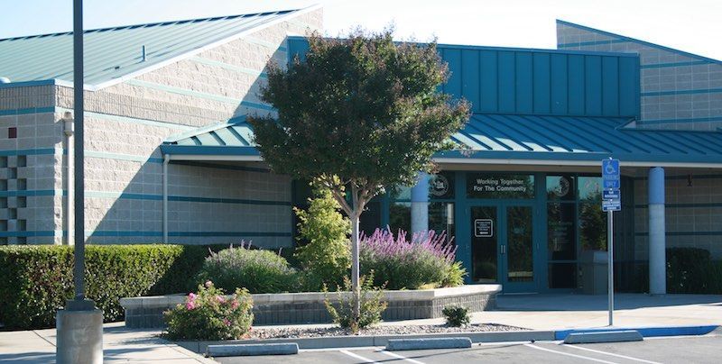 Exterior of the Gordon Center for the Performing Arts, blue roof, landscaping in front, sunny day.