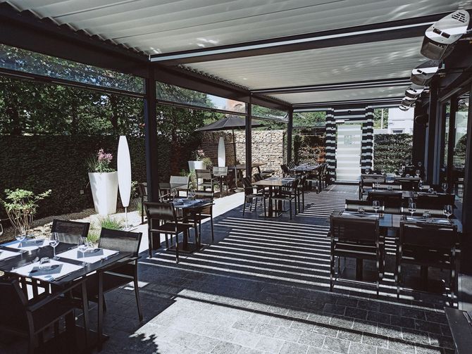 Commercial patio with a black retractable pergola system.