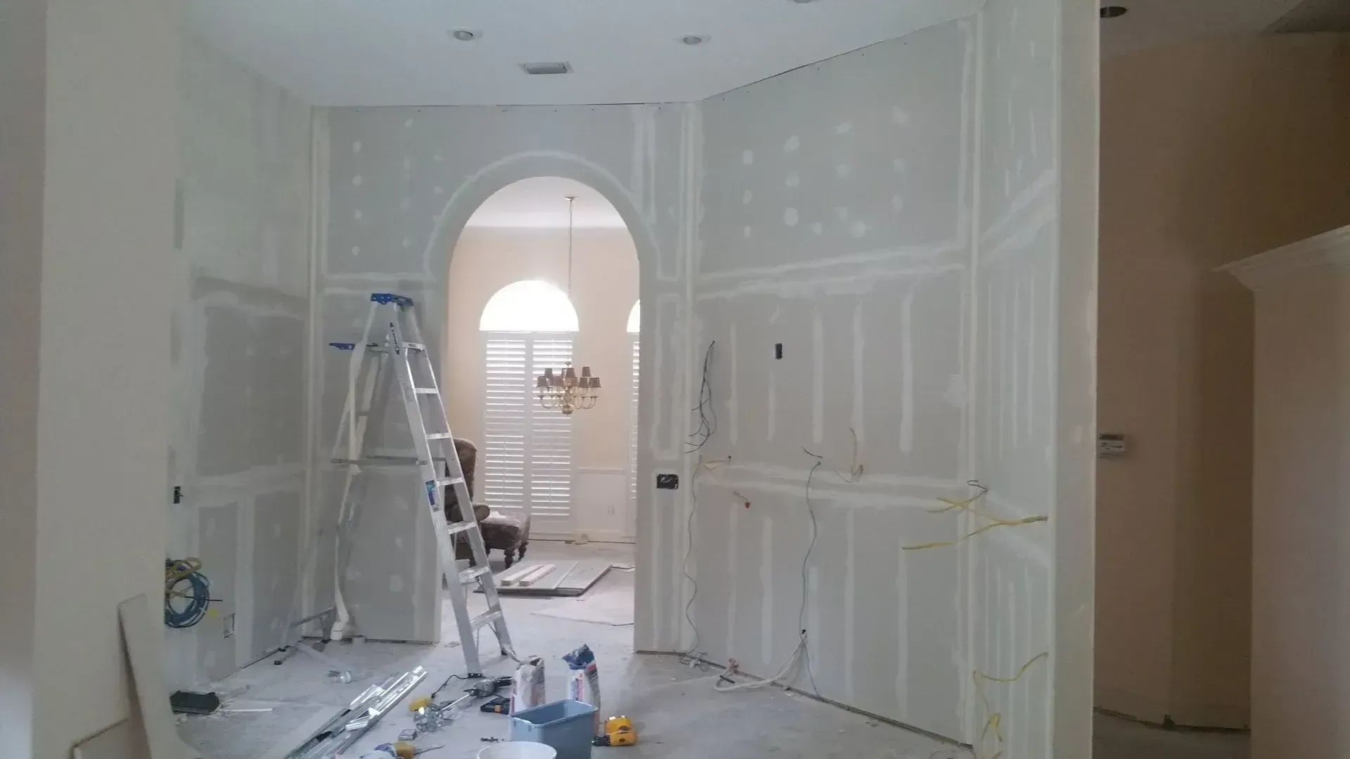 A room with a wall being built and pipes coming out of it.