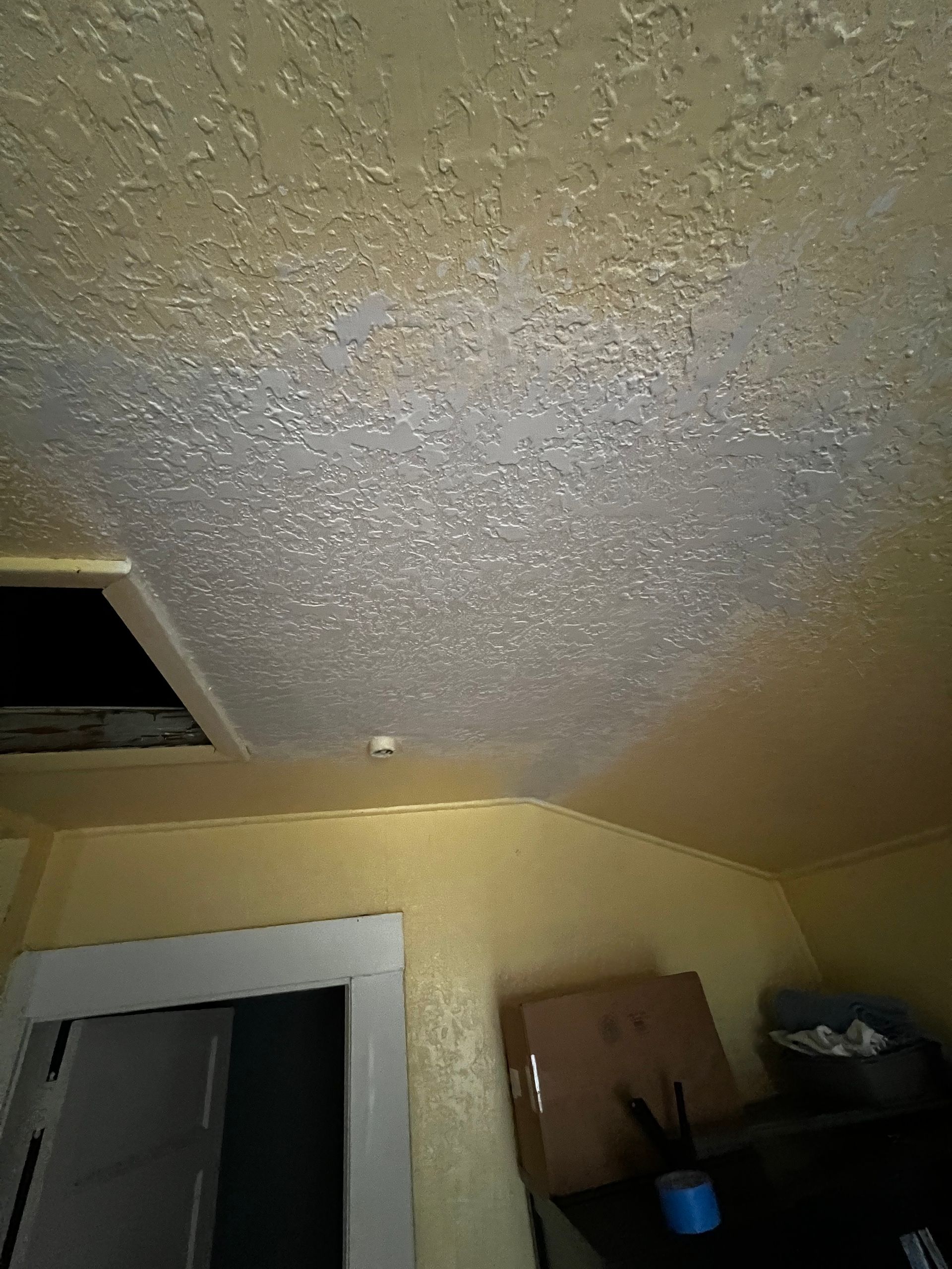 A room with a ceiling fan and a door.
